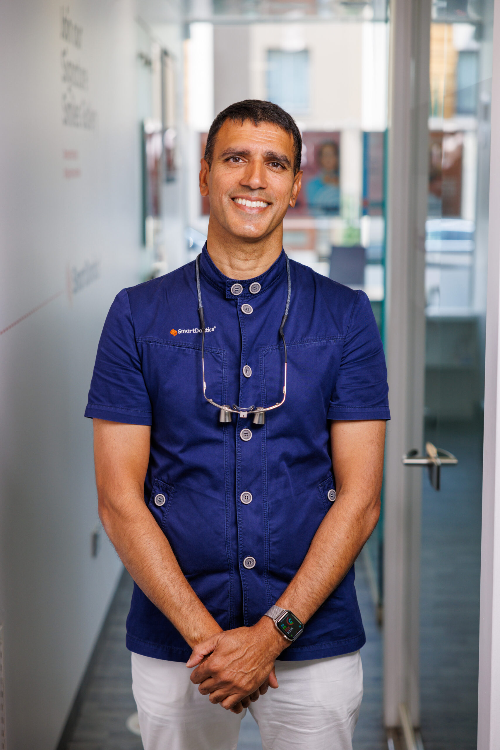 Dr Patel stood in clinic smiling at camera